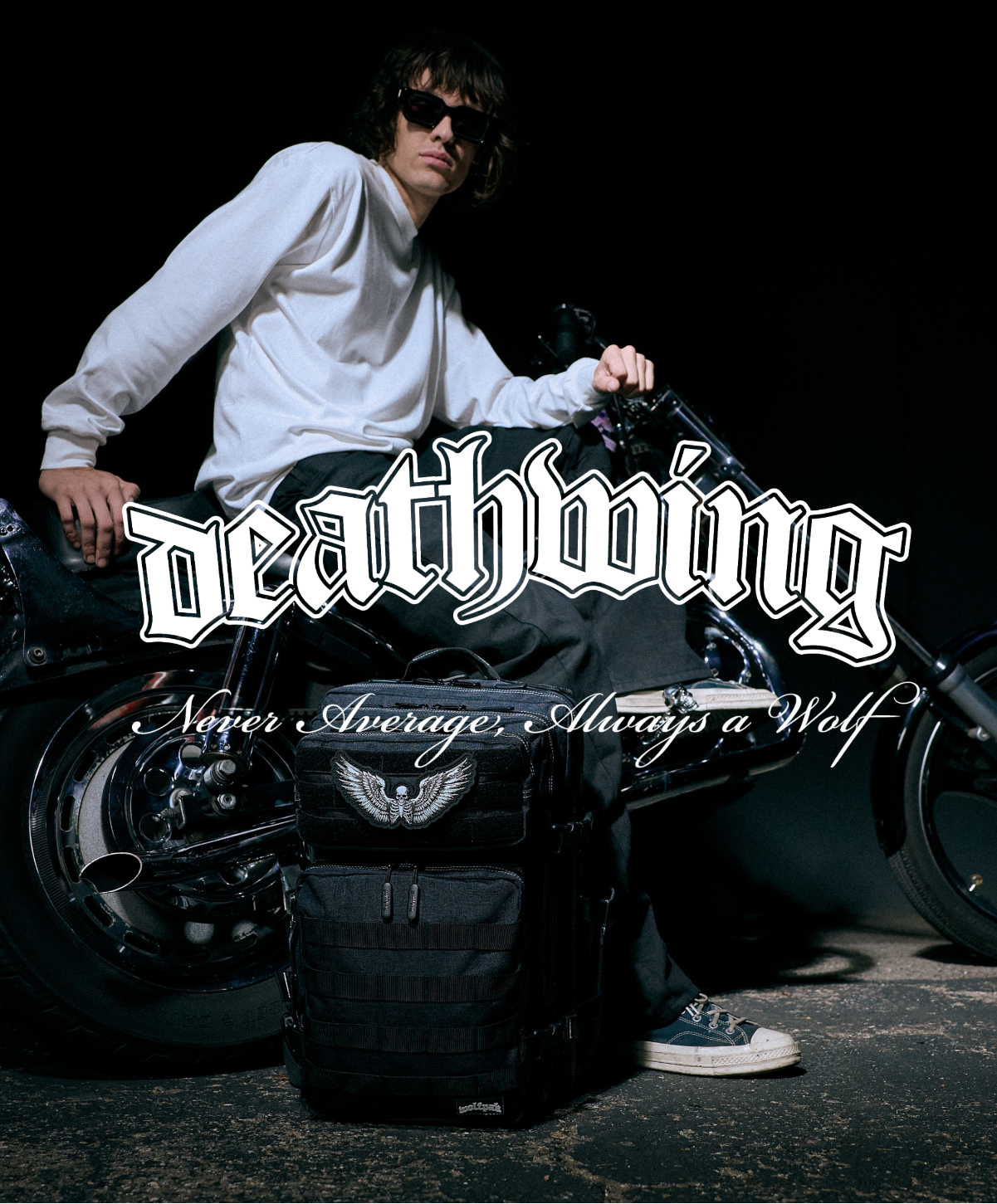 Person sitting on a motorcycle with 'deathwing' branding in the dark.