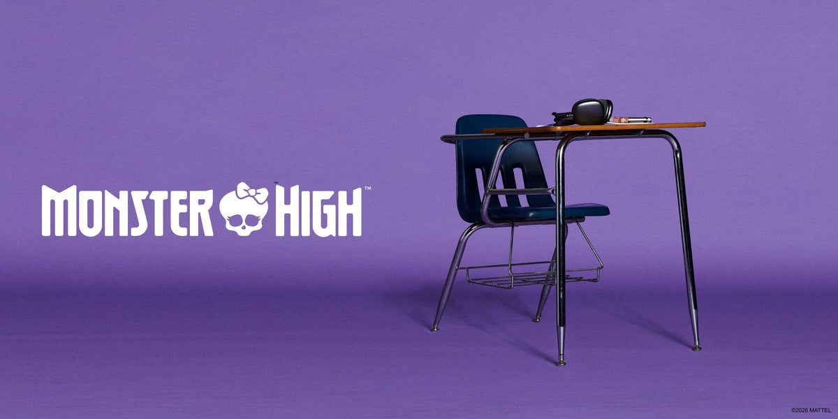 A purple promotional graphic featuring the Monster High logo on the left and a school desk with a dark blue chair on the right, styled like the Monster High World Tour collection.
