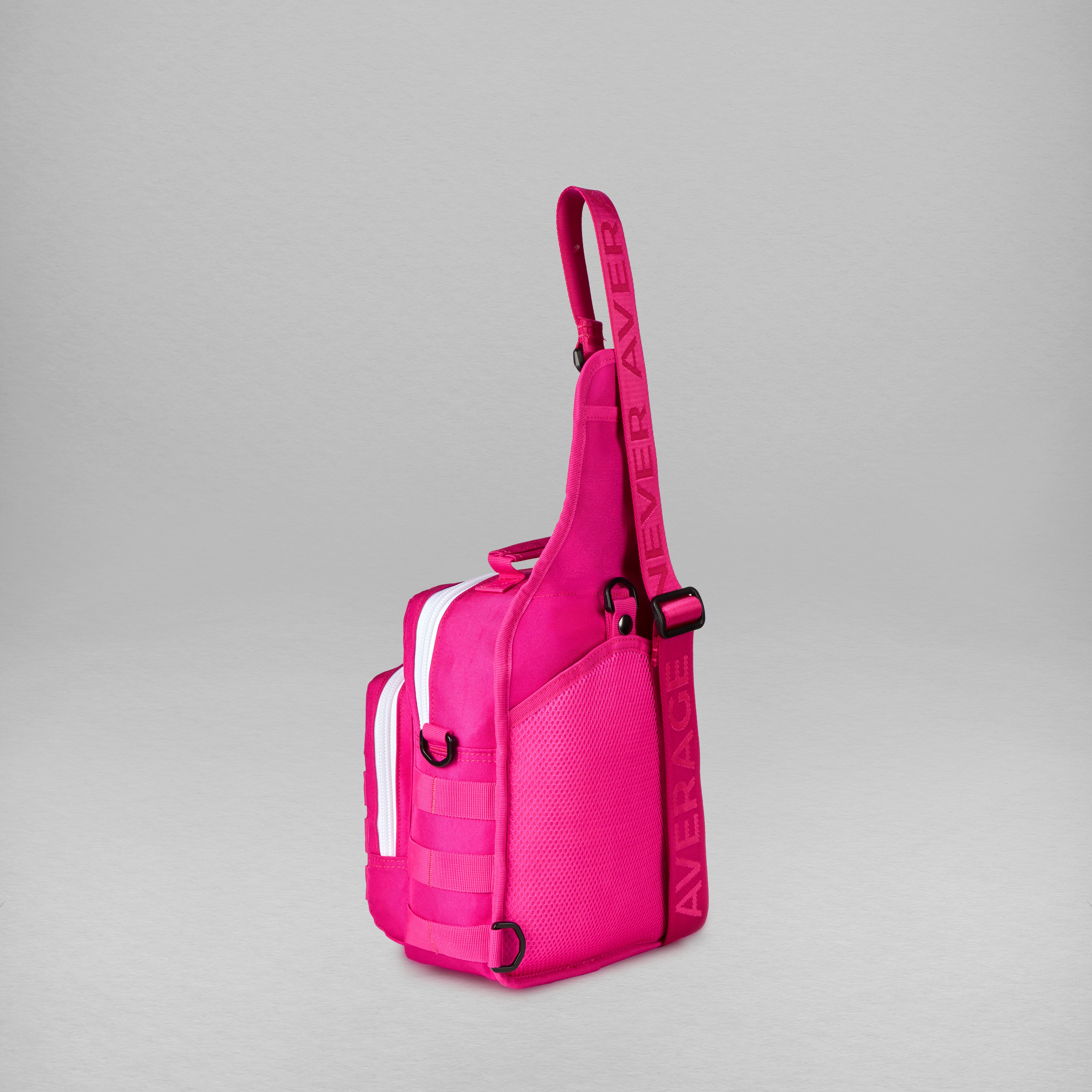 A bright pink sling bag with a wide shoulder strap, shown against a neutral gray background.
