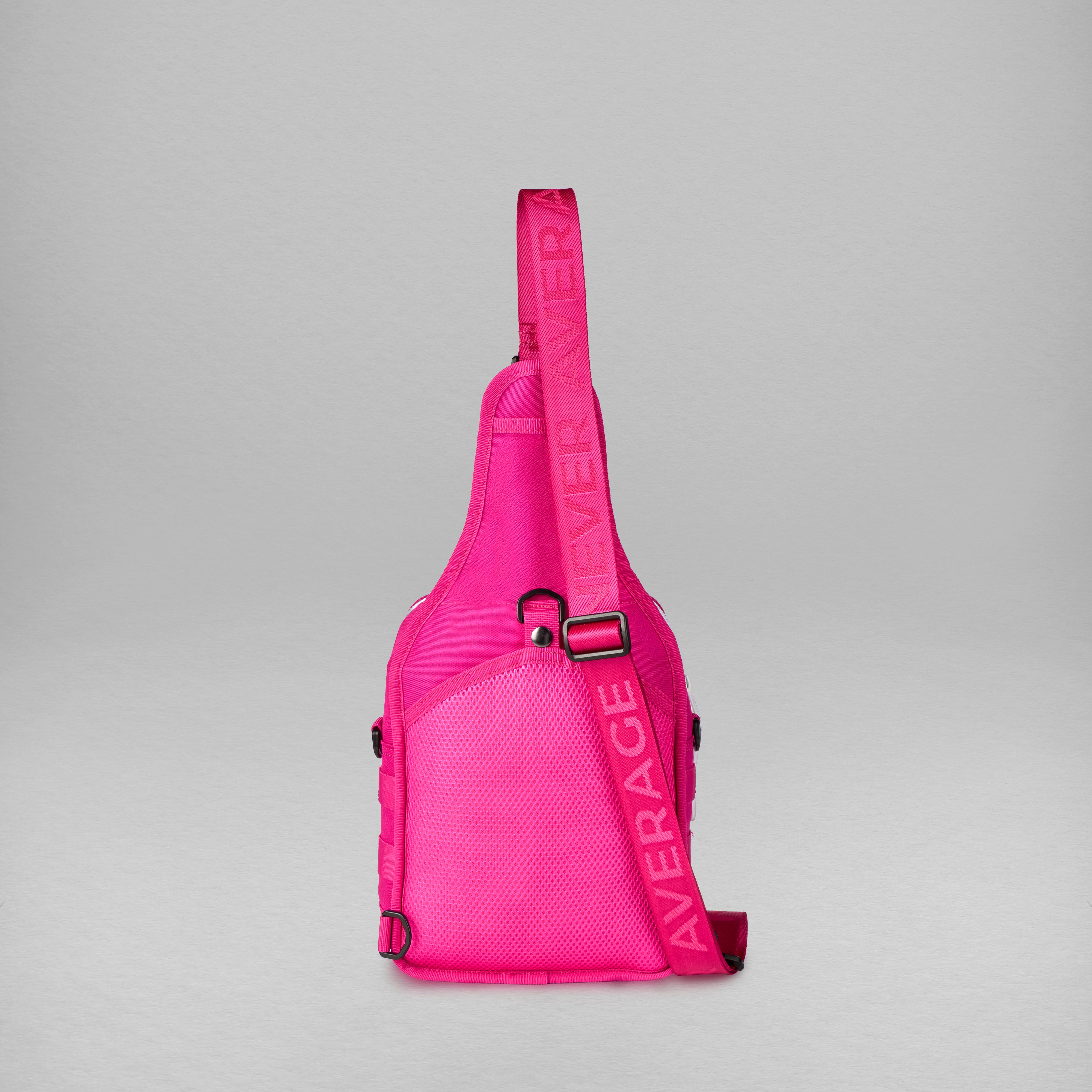 A bright pink sling bag with a wide adjustable strap, shown against a neutral gray background.