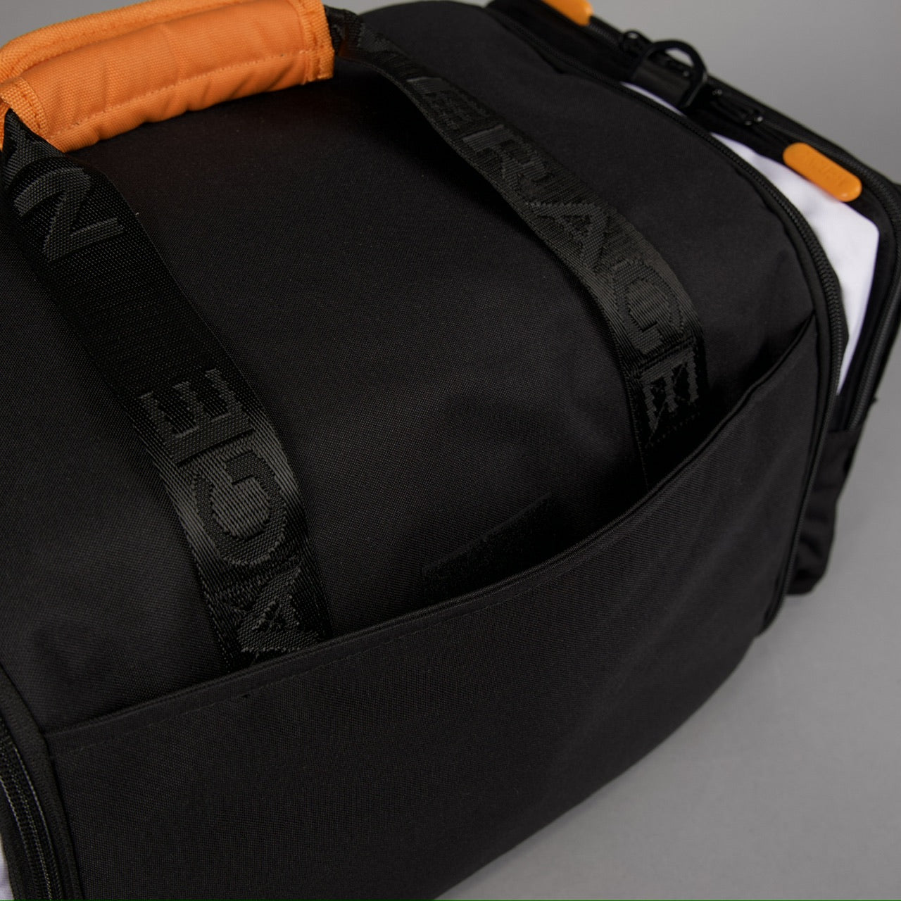 Bolsa de lona Ultimate de 30 L en negro Alpha con detalles en naranja y blanco